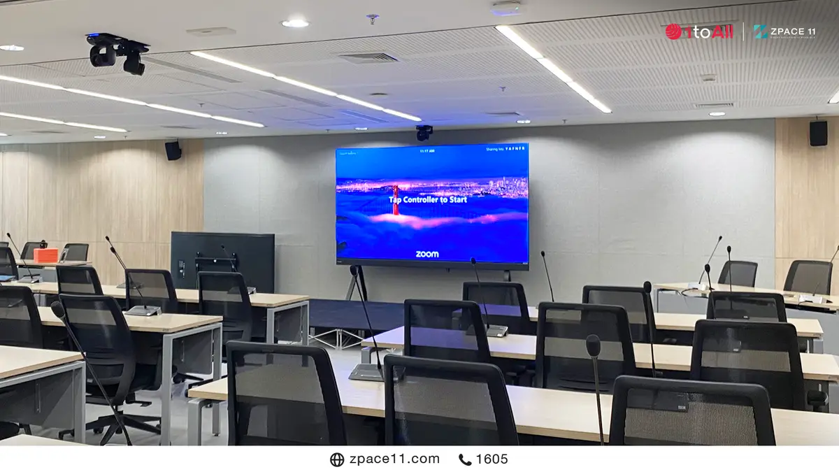 ห้องประชุมขนาดใหญ่ที่มีจอ LED ด้านหน้าและไมโครโฟนที่โต๊ะผู้เข้าร่วม