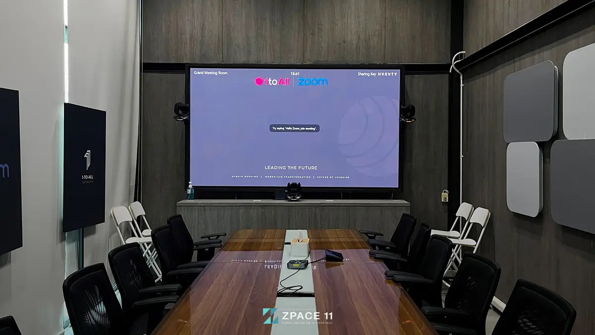 ห้องประชุมที่มีจอ LED ติดผนังด้านหน้าและโต๊ะประชุมยาว
