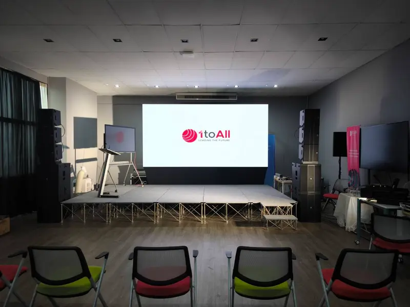 เวทีนำเสนอที่มีจอ LED ลำโพงไลน์อาเรย์ทั้งสองข้าง และแท่นบรรยาย