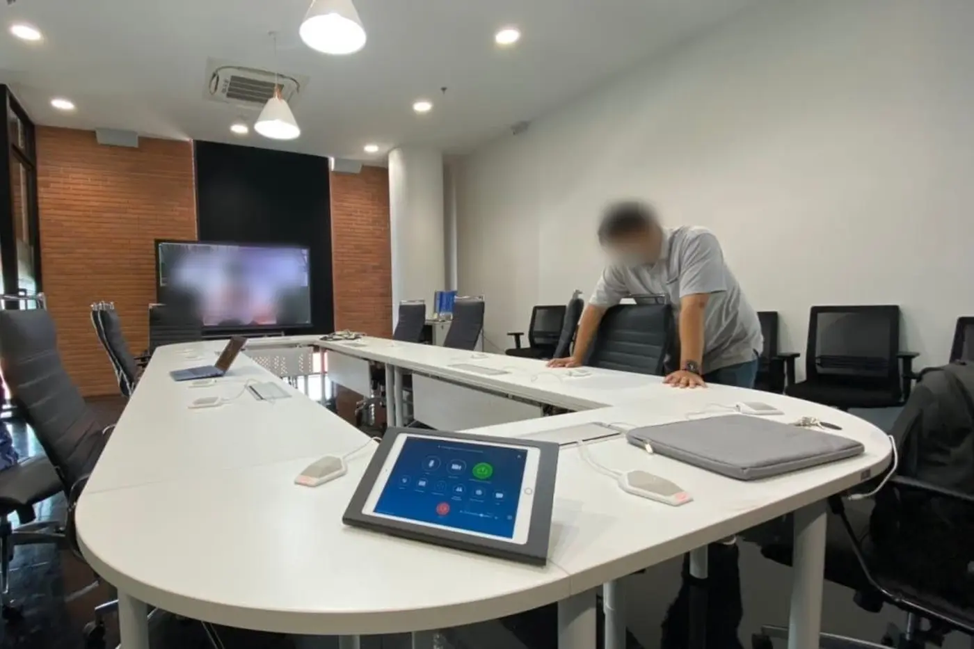 ห้องประชุมโต๊ะโค้ง พร้อมไมโครโฟนตั้งโต๊ะและแผงควบคุมห้อง
