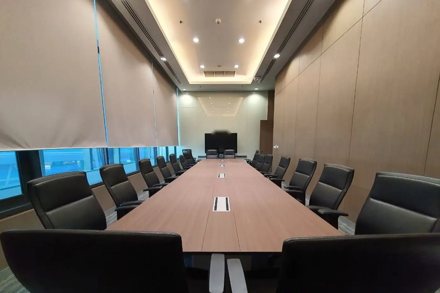 โต๊ะประชุมผู้บริหารแบบยาว ทอดสู่จอแสดงผลที่ปลายห้อง