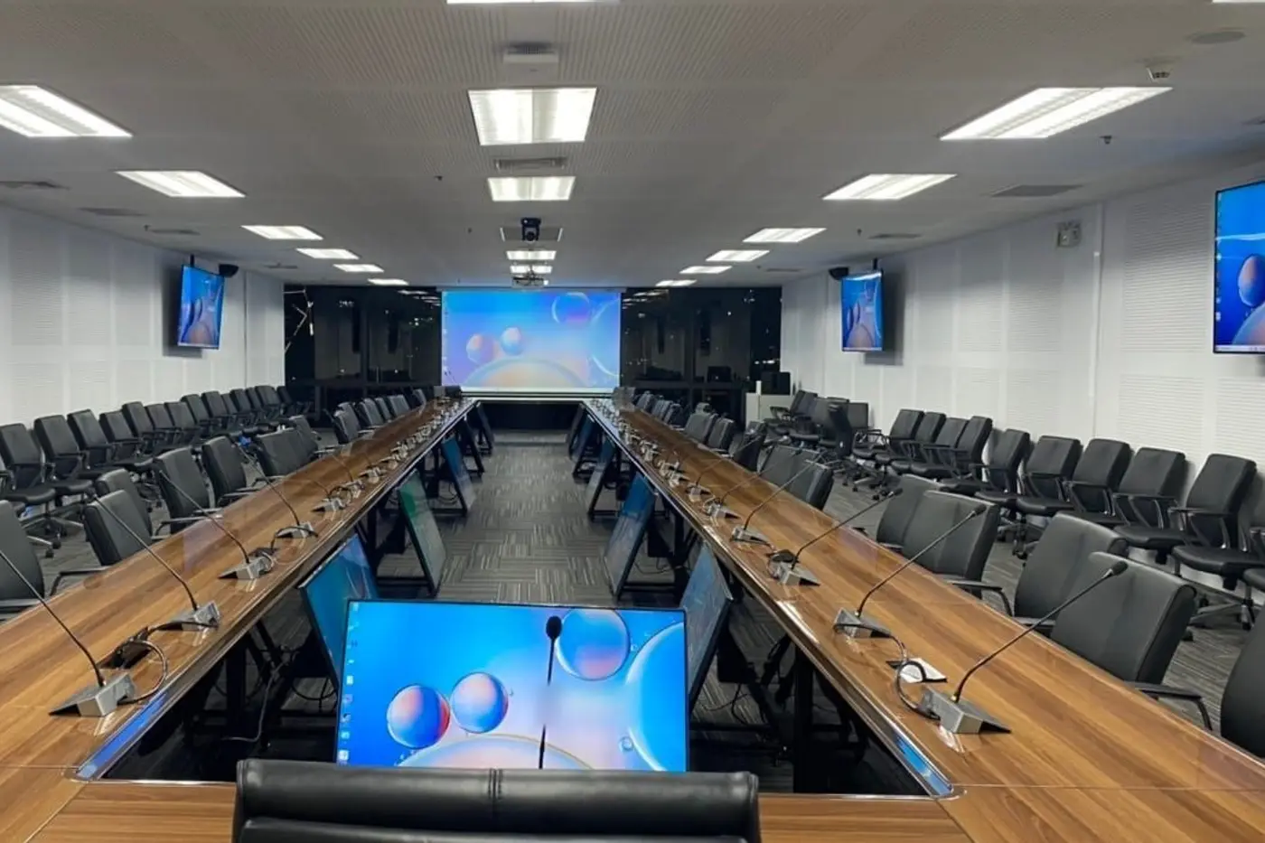 ห้องประชุมขนาดใหญ่ โต๊ะยาวสองแถว พร้อมจอแบบยกขึ้นลงและจอติดผนัง