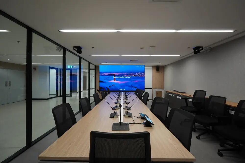 ห้องประชุมพร้อมไมโครโฟนทุกที่นั่ง และจอสำหรับประชุมทางไกล