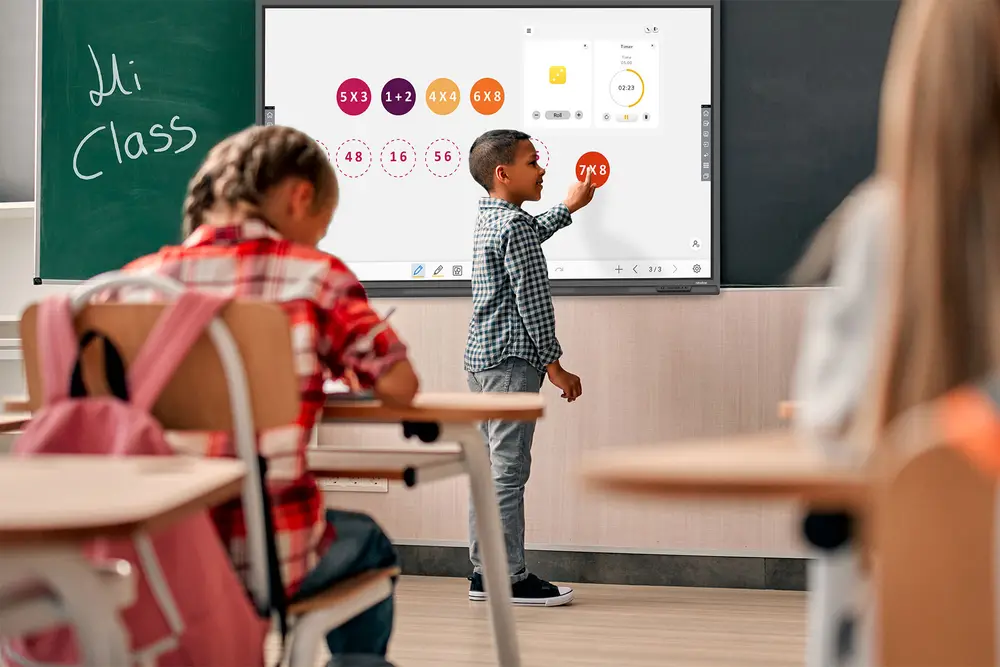นักเรียนกำลังเขียนบนจอ Interactive ของ Newline ในห้องเรียน